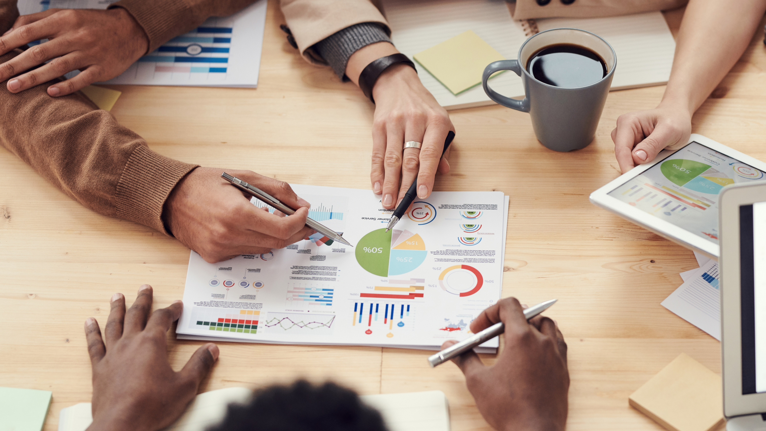 Group of professionals pointing at a chart about the SEO ranking of their business blog.